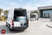 Sealed 25 litre jerrycans and a 1000 litre IBC of demineralised water in a delivery van at a Muscat plant gate